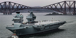 An aircraft carrier pictured sailing from a dockyard
